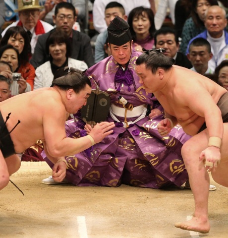 相撲冠軍Hakuho在2013年春季相撲錦標賽上面對宿敵Haruma-fuji的場面，身旁密切關注對決的是第36代行司Shonosuke Kimura（照片：美國商業資訊）