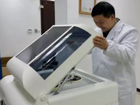 Anpac Bio-Medical Science Company CEO Dr. Chris Yu inspects one of the company's proprietary 