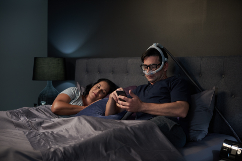 在卧床阅读的男士佩戴AirFit N30i CPAP鼻罩（照片：美国商业资讯） 