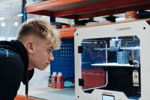 14岁的Harris Gribble看着3D打印机正在制作Open Bionics Hero Arm（照片：美国商业资讯）