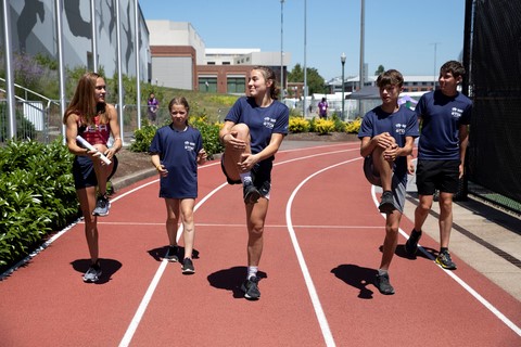 Team USA athlete Sinclaire Johnson guides young participants through their pre-race exercises. (Photo: Business Wire)