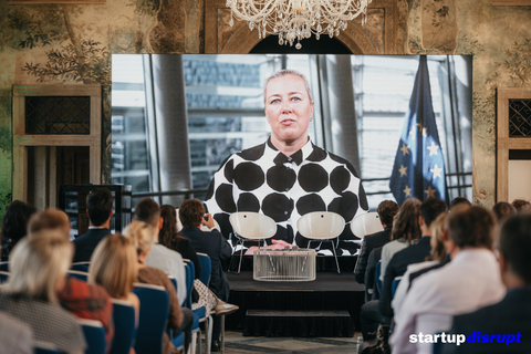在捷克布拉格歷史悠久的馬丁尼茲宮舉行的永續未來會議上，一位主題演講人透過電視轉播發表演講。（圖片來源：Startup Disrupt）
