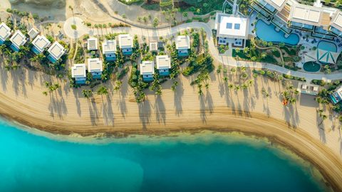 Aerial view of Jayasom Wellness Resort AMAALA, capturing the resort’s beachfront location on Triple Bay and its surrounding natural beauty.

