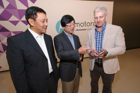 (from left to right) Liu Jun, EVP, Lenovo, President Mobile Business Group, Lenovo and Chairman of the Motorola Management Board; Yang Yuanqing, Lenovo Chairman and CEO; and Rick Osterloh, President and COO, Motorola Mobility celebrate the closing of Lenovo's acquisition of Motorola Mobility today. Here Rick Osterloh demonstrates the latest features of the new Nexus 6 smartphone in front of the company's new logo. (Photo: Business Wire)
